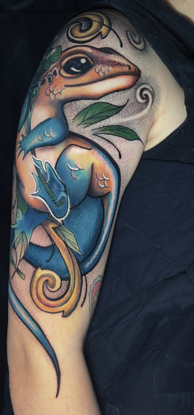 Lagartija azul y dorado en brazo